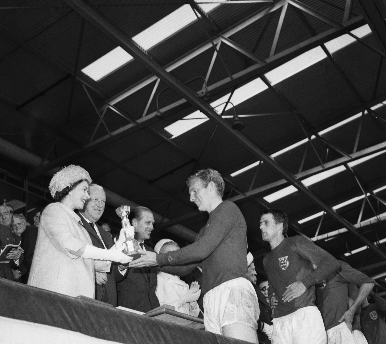 Regina Elisabeta îi înmânează lui Bobby Moore trofeul Cupei Mondiale. Sursă: The Sun/ Getty Images